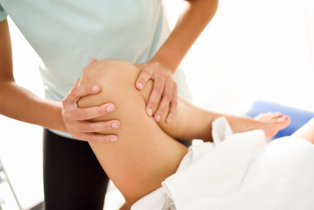 Der Spezialist macht eine therapeutische Massage mit Kniearthrose